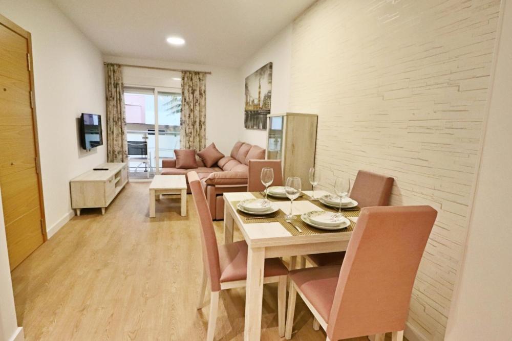 comedor con mesa, sillas y sofá en Poeta 2 Bedroom Apartment, en Fuengirola