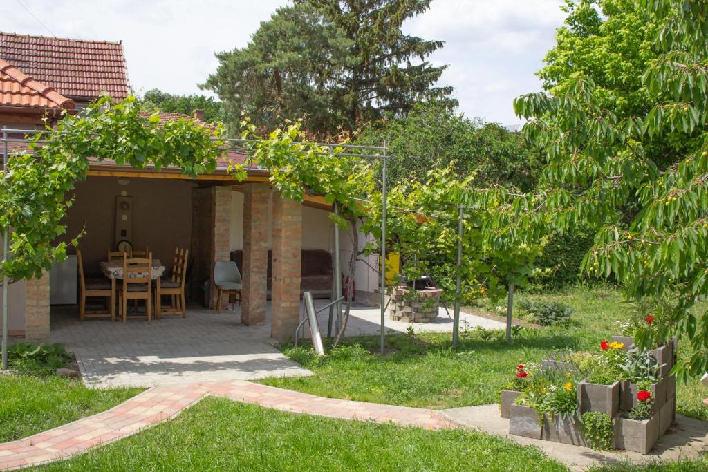 a garden with a table and a pergola at Ilona Apartman in Gyula