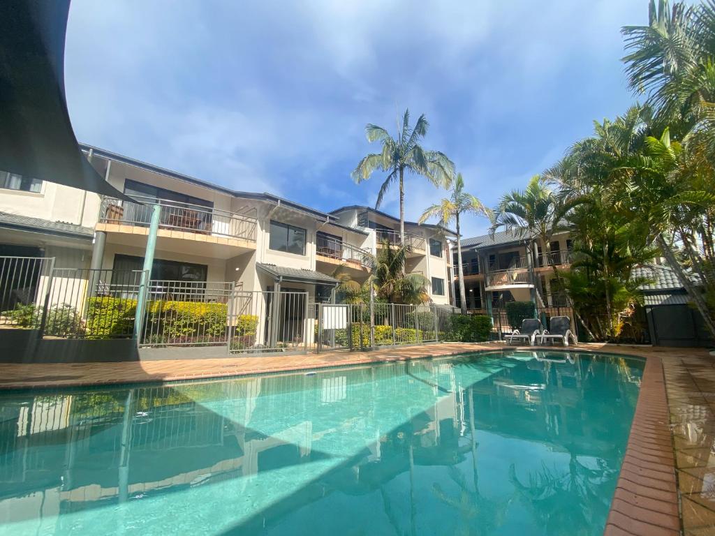 a large swimming pool with a balcony overlooking the ocean at Beaches Holiday Resort in Port Macquarie