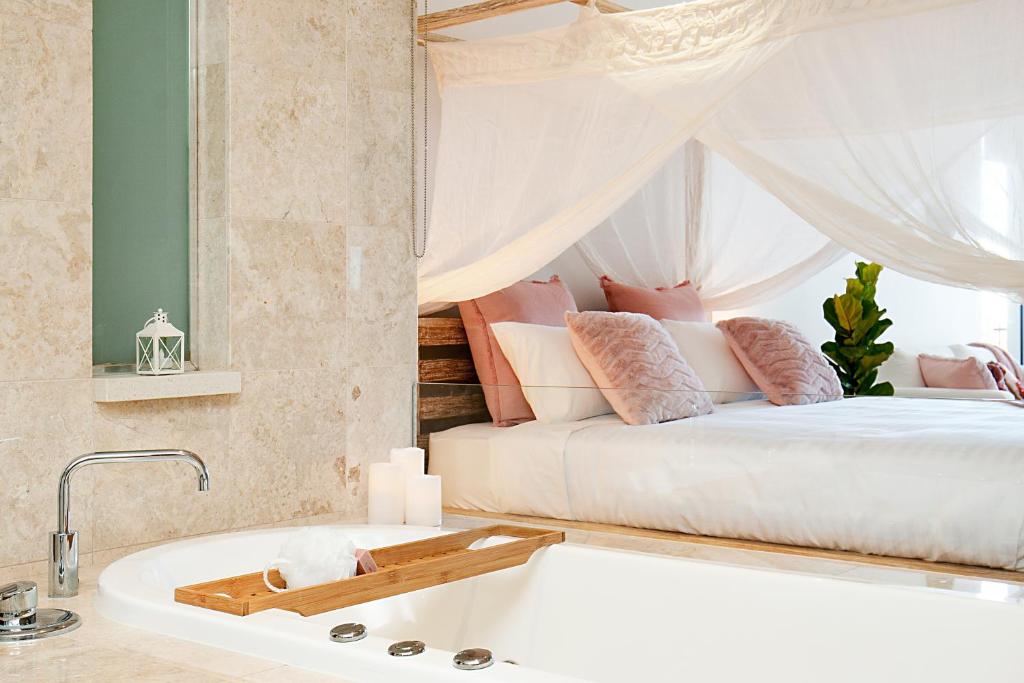 a bedroom with a bed and a bath tub at 128 Santai - Stylish Resort Apartment by uHoliday in Casuarina
