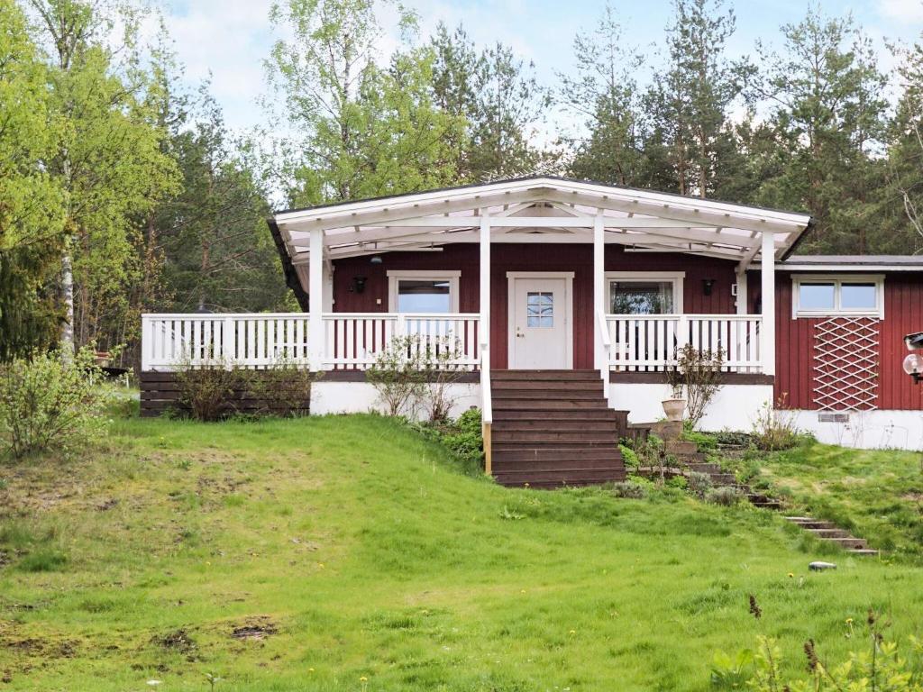 uma pequena casa vermelha e branca com um alpendre em Holiday home STRÄNGNÄS em Strängnäs