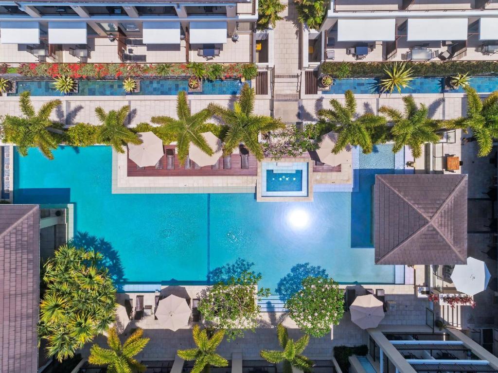 an overhead view of a swimming pool with palm trees at 208 Santai - Spacious Family Apartment by uHoliday in Casuarina