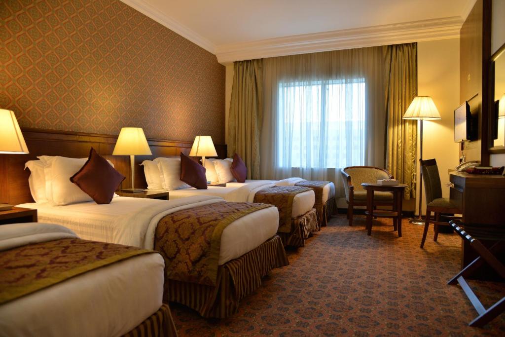 En eller flere senger på et rom på Nozol Royal Inn Hotel