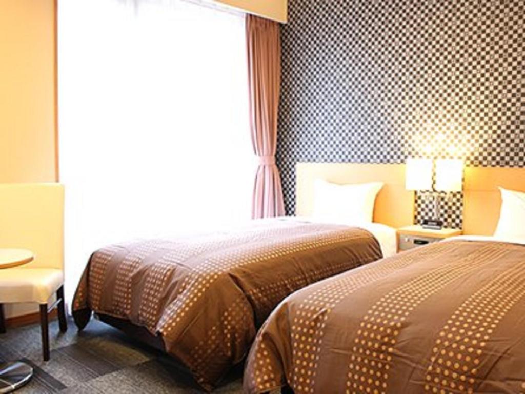 Postel nebo postele na pokoji v ubytování HOTEL LiVEMAX BUDGET Chiba Mihama