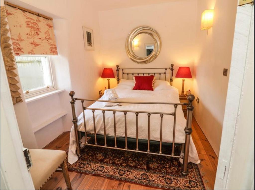 1 dormitorio con cama y espejo en New Thatch Farm, knocklong, Limerick, en Cross of the Tree