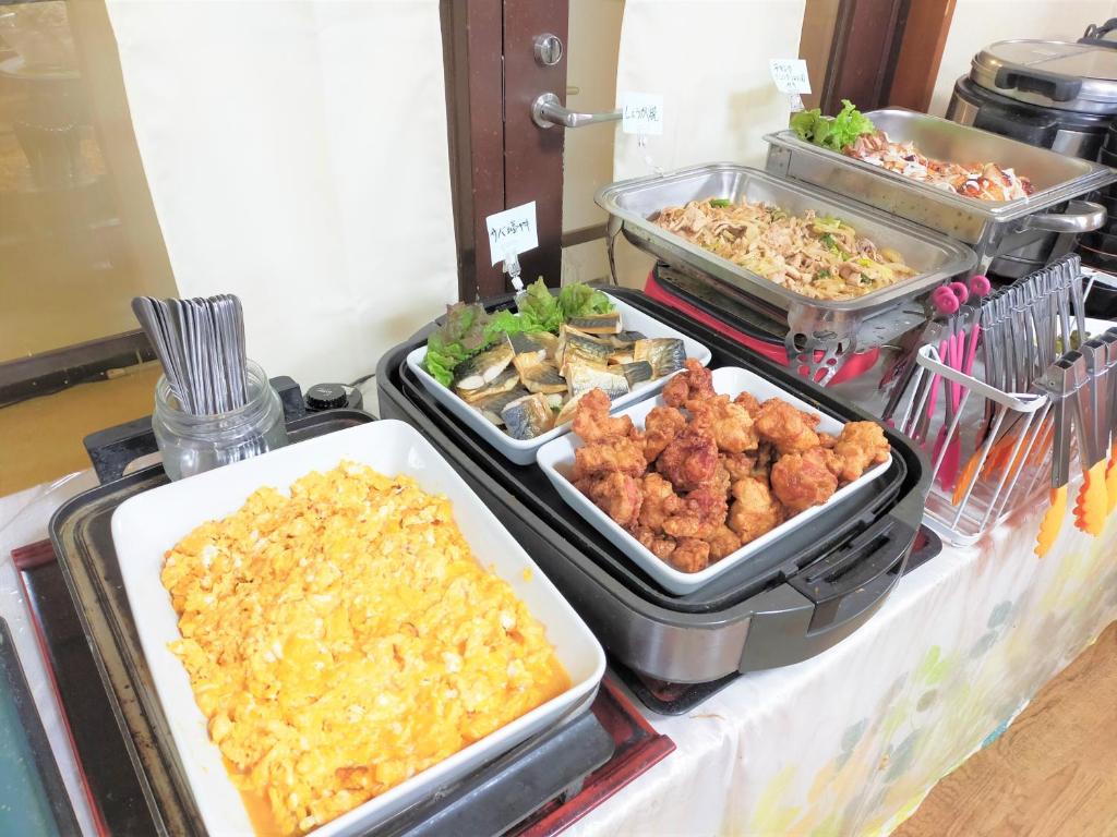 a buffet with several trays of food on a table at Tabist Business Hotel Takizawa Takasaki Station Nishiguchi in Takasaki