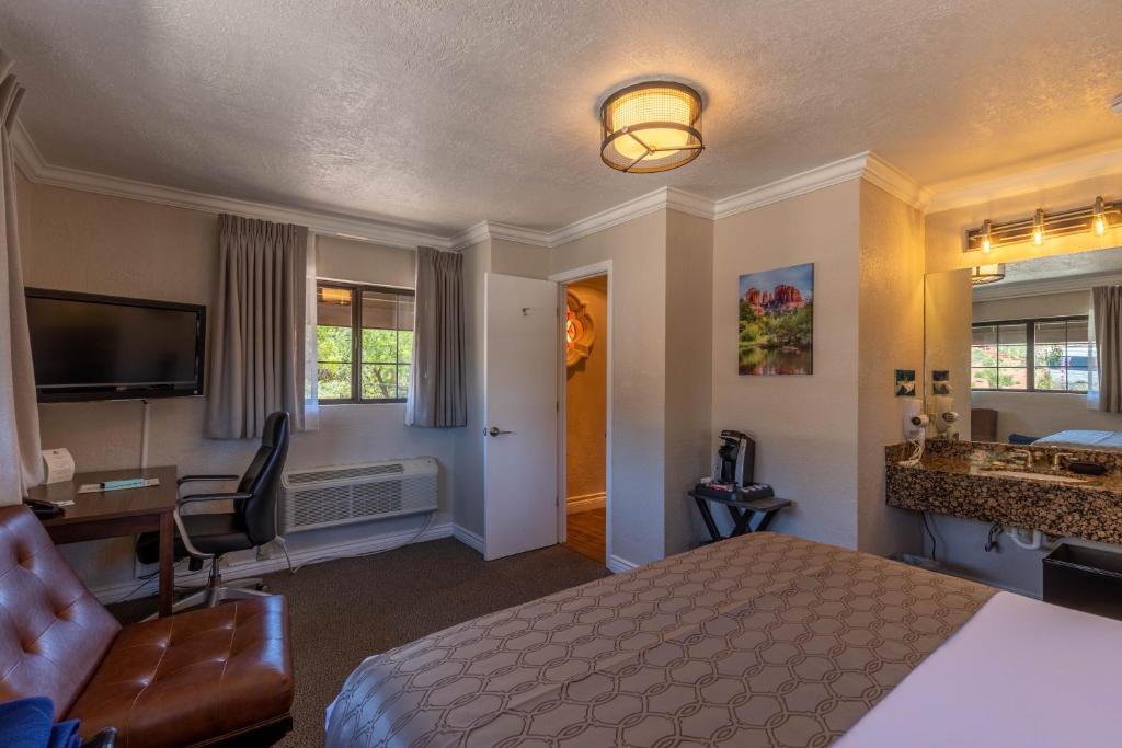 a hotel room with a bed and a desk and a sink at Cedars Resort in Sedona
