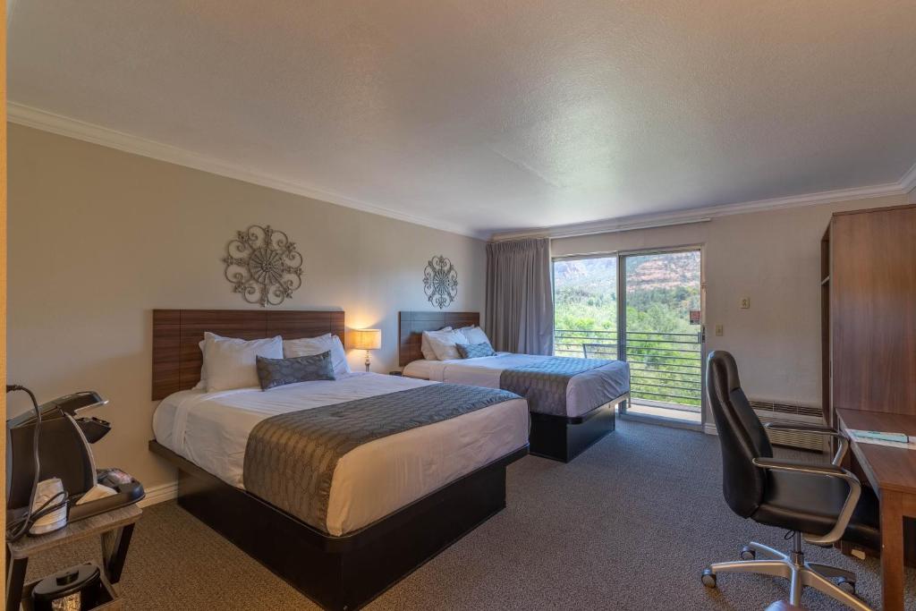 a hotel room with two beds and a desk at Cedars Resort in Sedona