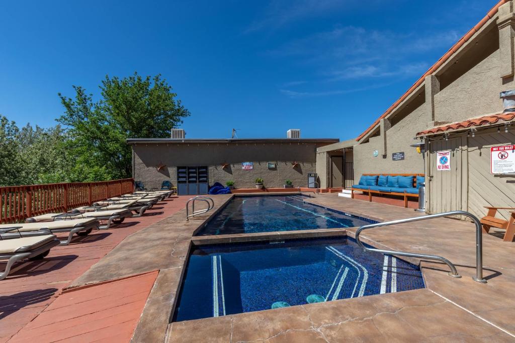 a swimming pool on a deck with lounge chairs next to a building at Cedars Resort in Sedona