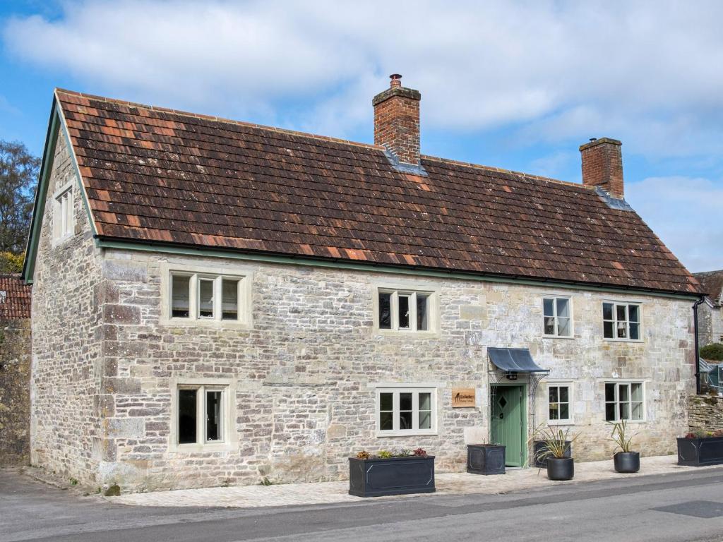 een oud stenen gebouw met een bruin dak bij Enderley in Salisbury