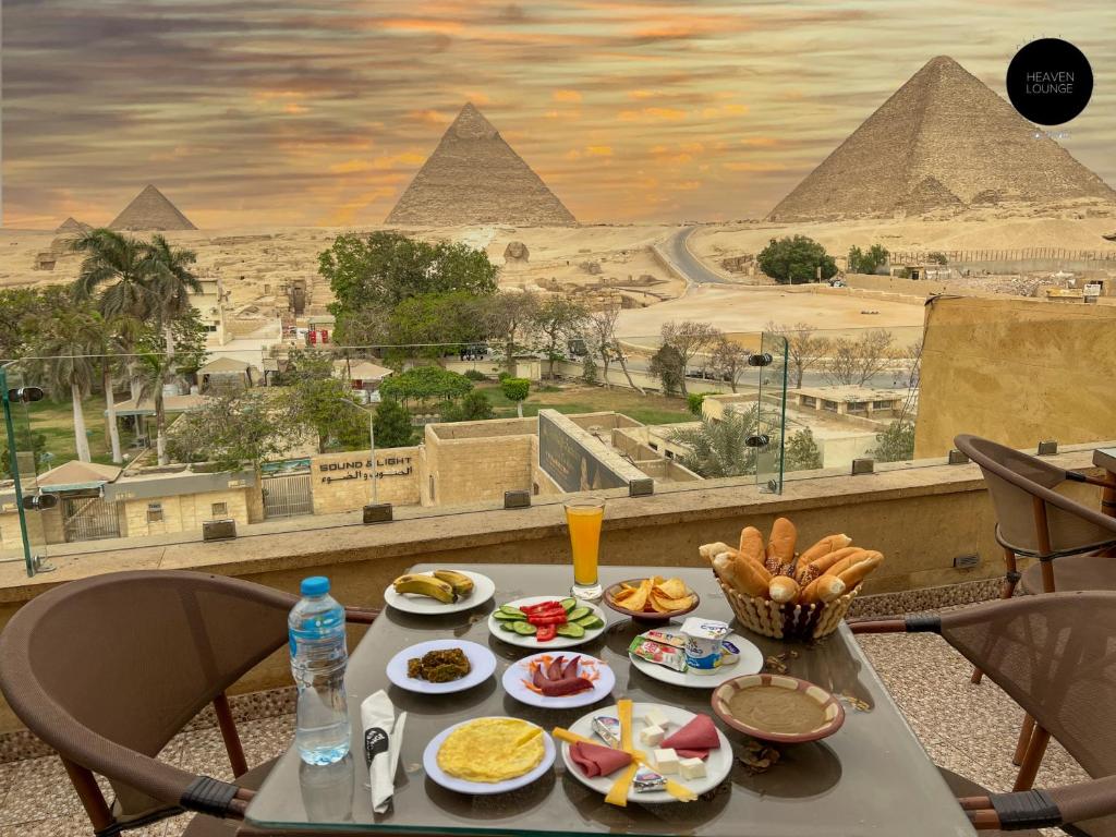 une table avec de la nourriture et une vue sur les pyramides dans l'établissement Giza Pyramids View Inn, au Caire