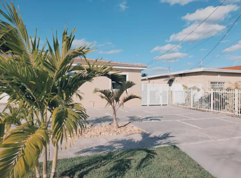 une maison avec des palmiers en face d'une allée. dans l'établissement Guayabita's House, à Miami