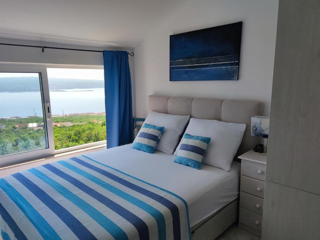 a bedroom with a bed and a large window at Art Gallery House in Crikvenica