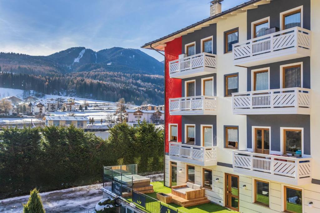 um edifício de apartamentos com vista para as montanhas em Hotel Vittoria - Ricarica l'anima em Dimaro
