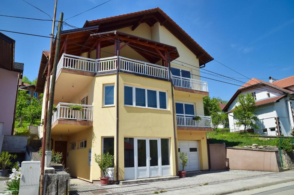 a yellow house with a balcony on a street at Apartman Buongiorno in Jajce