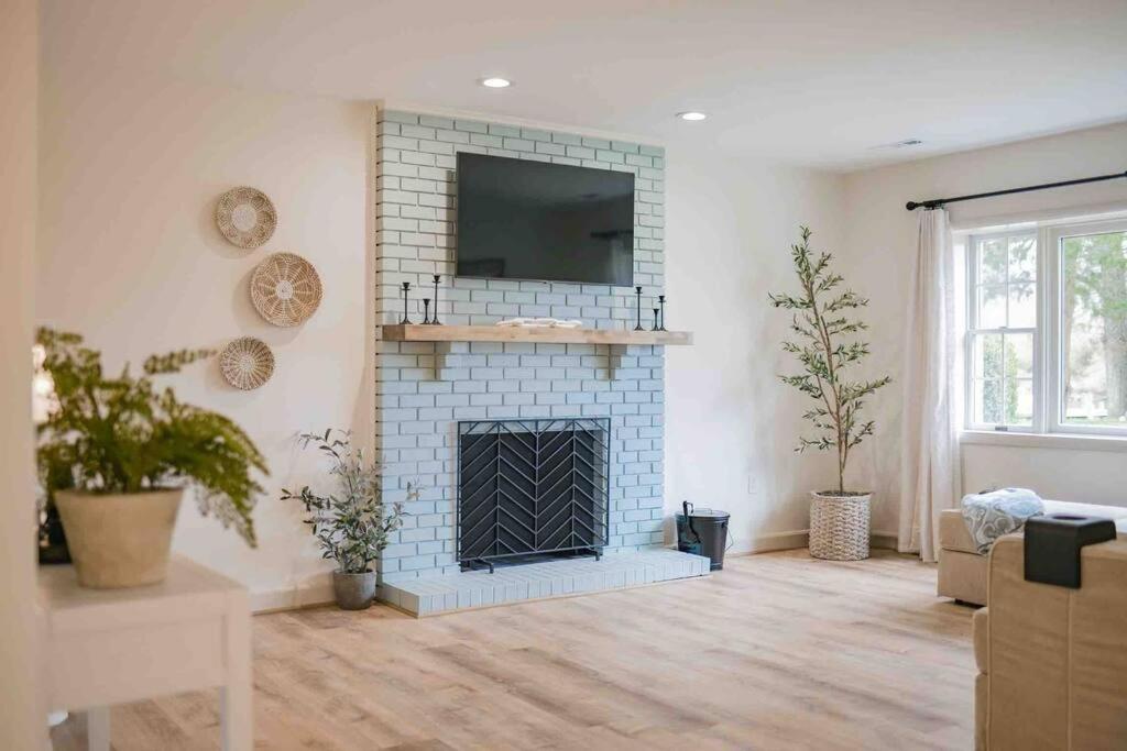 a living room with a blue brick fireplace at Annapolis Charm Waterfront Getaway - Near Beach - FISH & CRAB from your PRIVATE PIER! in Annapolis