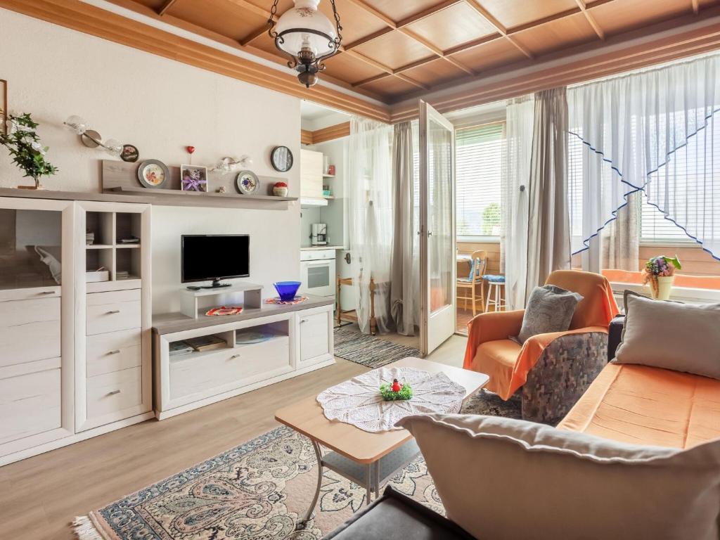 Apartment in Carinthia on Lake Woerthersee في تشلسبرغ ام وورث: غرفة معيشة مع أريكة وطاولة