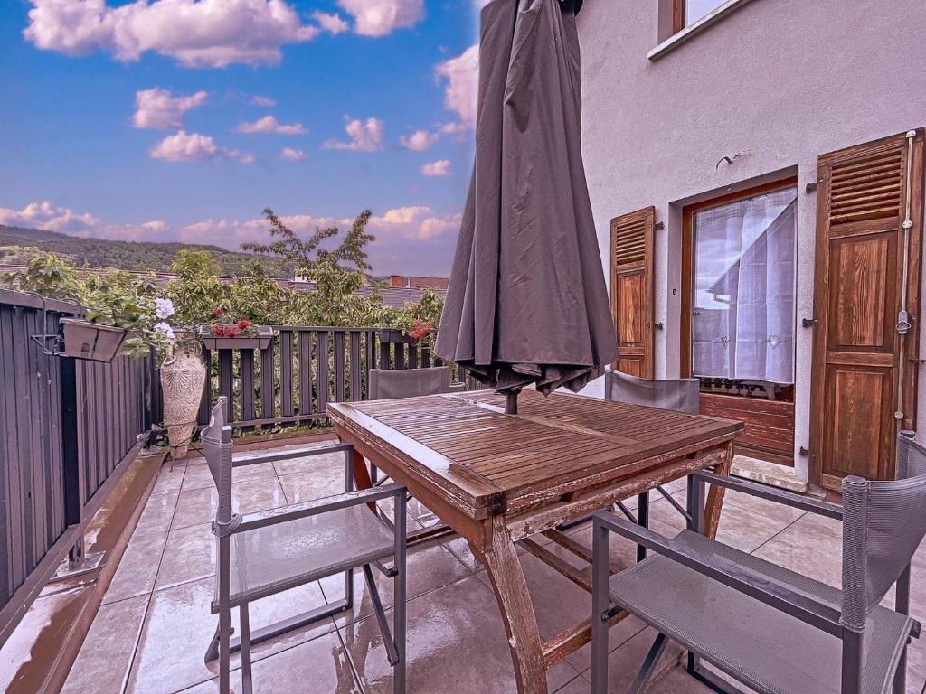 リクヴィールにあるAppartement 2 chambres au cœur du vignoble avec terrasseの木製テーブル、バルコニー(椅子、パラソル付)