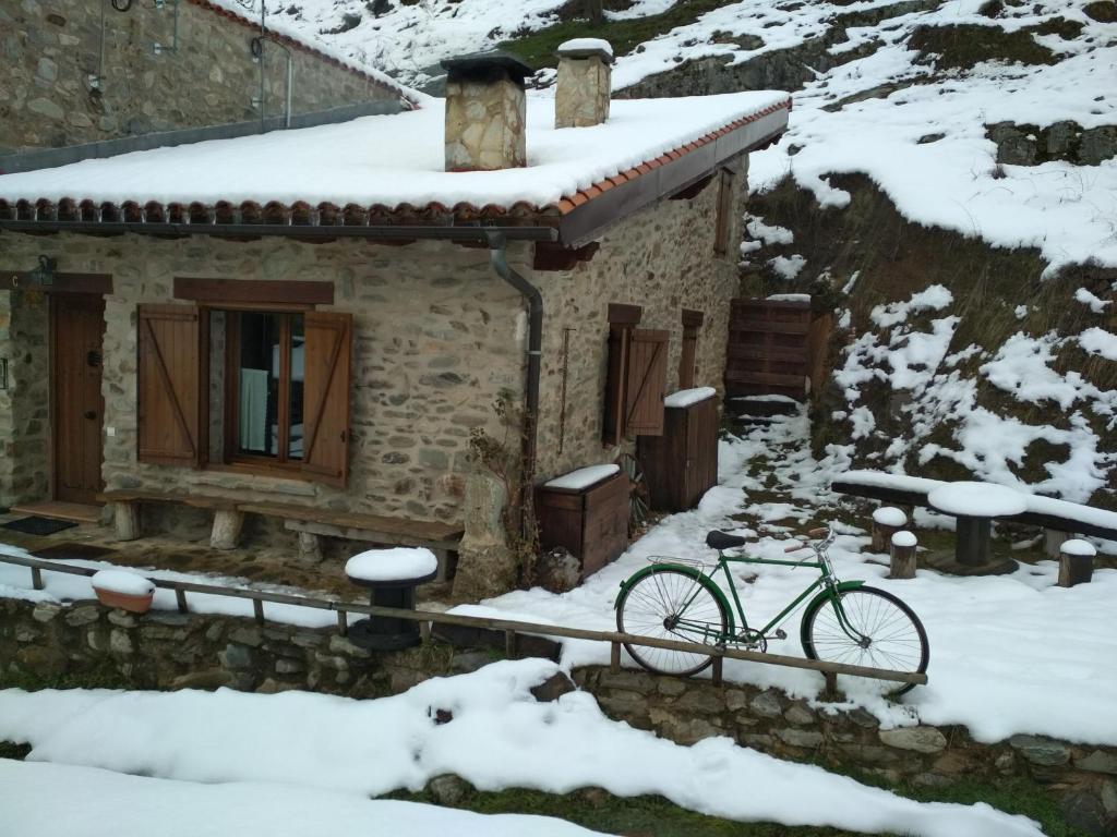 una bicicleta estacionada fuera de un edificio en la nieve en Zaldierna al sol, aldea del siglo XVIII Ezcaray, en Zaldierna