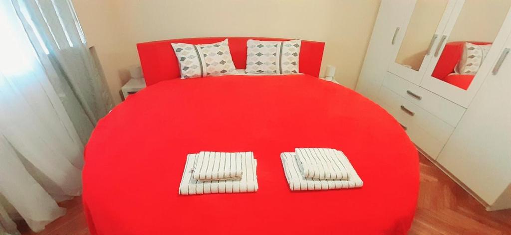 a red table with two towels on top of it at Apartment Alex 2 in Belgrade