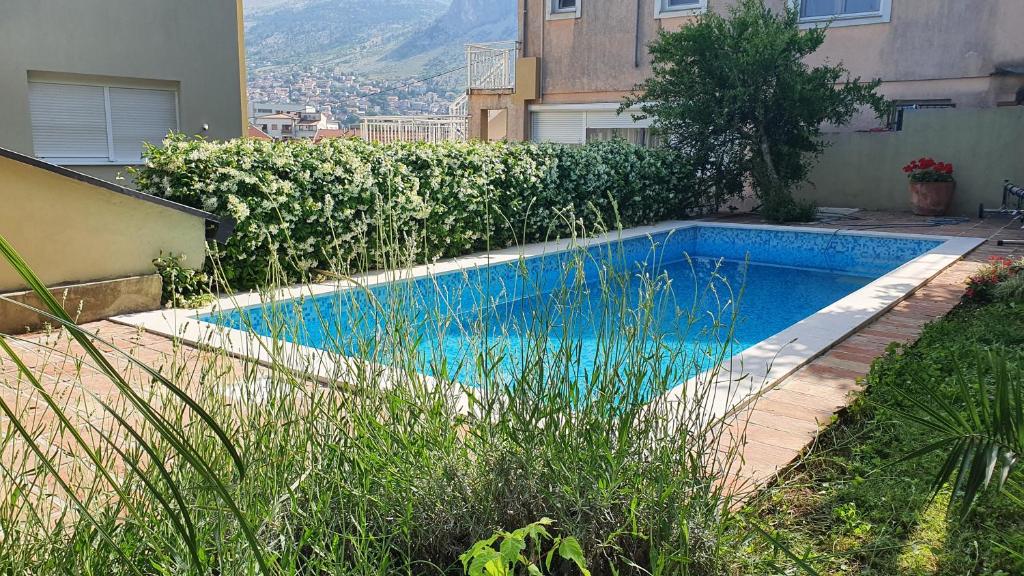 a swimming pool in a yard next to a building at Villa AYA - with sauna and outdoor swimming pool in Mostar