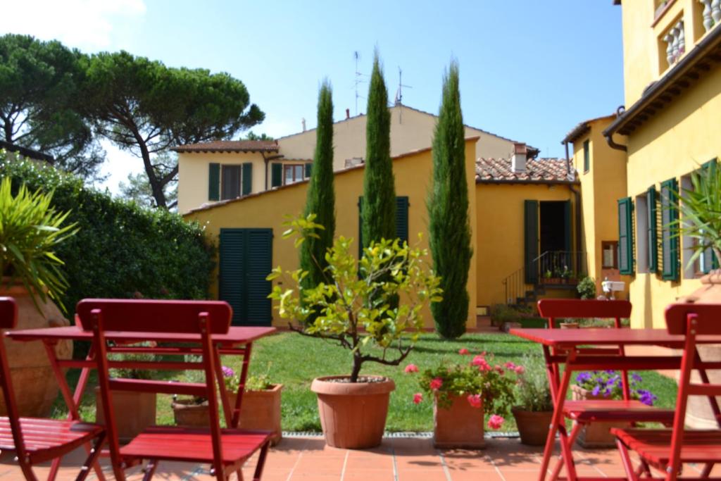 eine Gruppe roter Stühle und Tische in einem Hof in der Unterkunft Al Canto B&B in Florenz