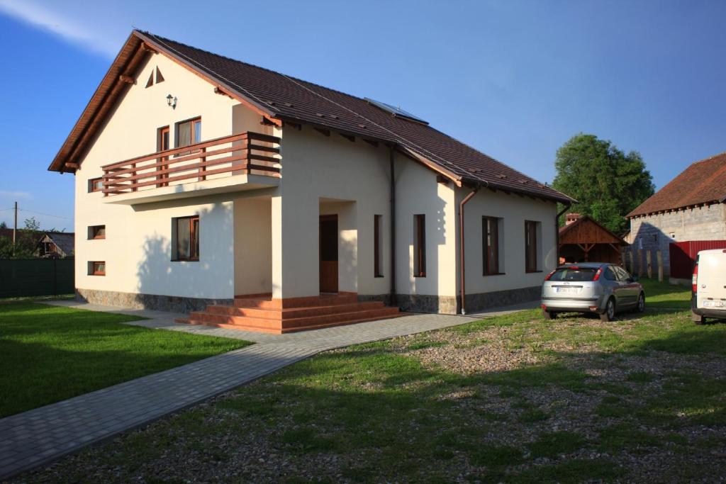 una casa con un coche aparcado delante de ella en Casa Dragusana, en Drăguş