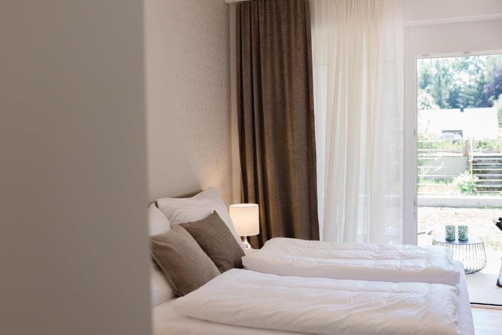 een hotelkamer met 2 bedden en een raam bij Haus Karlsbad - neu und modern in Velden am Wörthersee