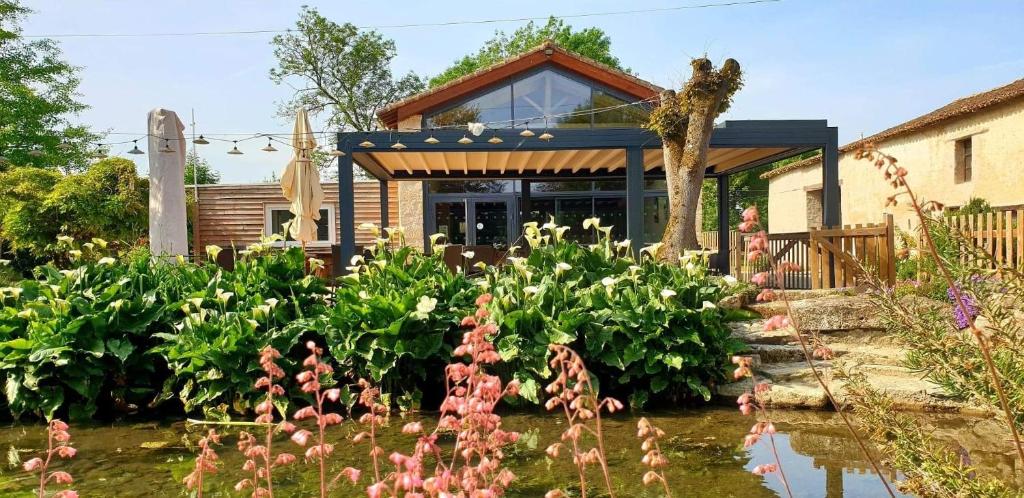 a garden with flowers in front of a house at Le Petit courault in Pamproux