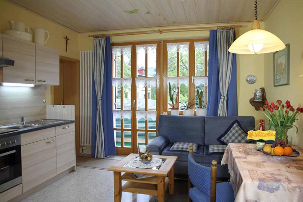 a living room with a blue couch and a table at Landhaus Panorama in Bayerisch Eisenstein