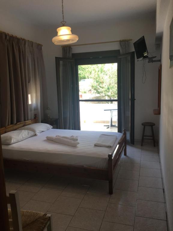 sypialnia z łóżkiem, oknem i telewizorem w obiekcie Alekos Rooms and Apartments w mieście Kokkari