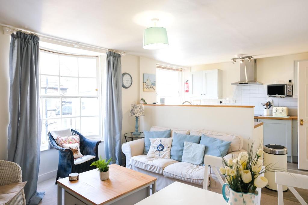 een woonkamer met een bank en een tafel bij Elizabeth: Charming two bedroom apartment in centre of town in Ramsgate