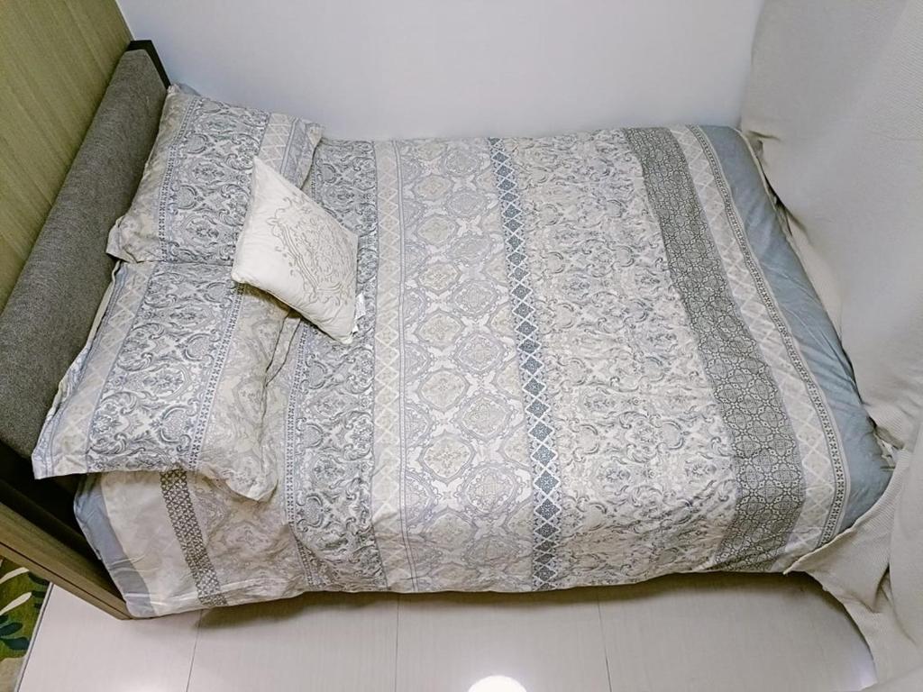 a bed with a blanket and pillows on it at Home away from Home in Manila