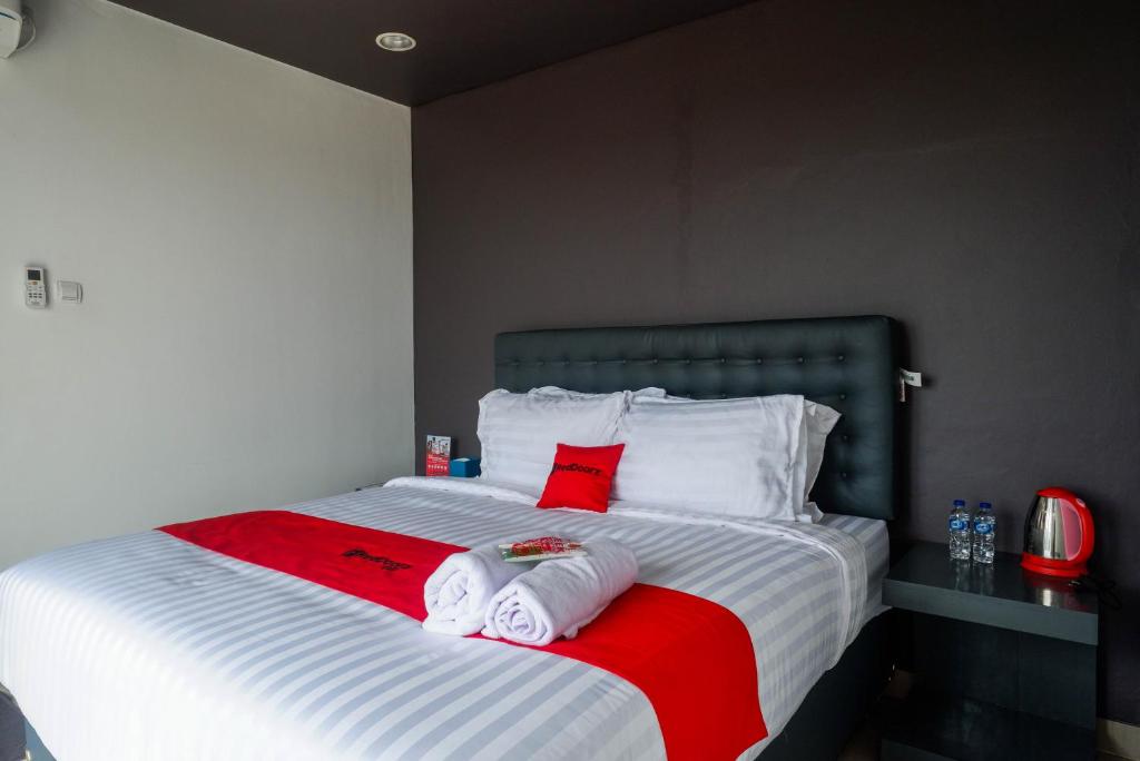 a bedroom with a bed with towels on it at RedDoorz near Bukitsari Semarang in Jatingaleh