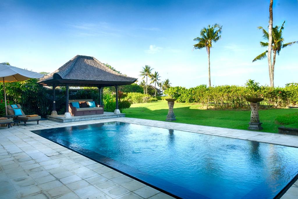 einen Pool im Hinterhof mit Pavillon in der Unterkunft Villa Nirwana in Tanah Lot