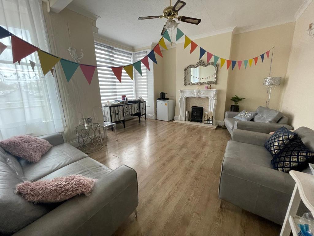 a living room with two couches and a ceiling fan at South Dene Hotel in Bridlington