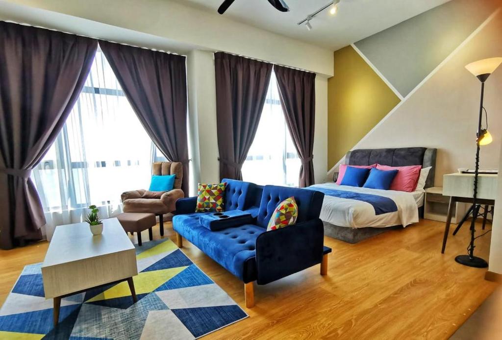 a living room with a bed and a blue couch at Gothca Imperium Residence Kuantan Studio Seaview in Kuantan