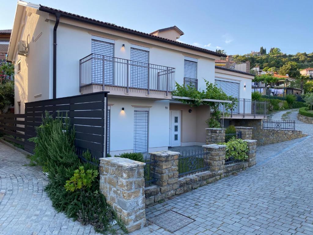 une maison blanche avec une clôture noire et une allée. dans l'établissement Apartmaji Vera, à Portorož