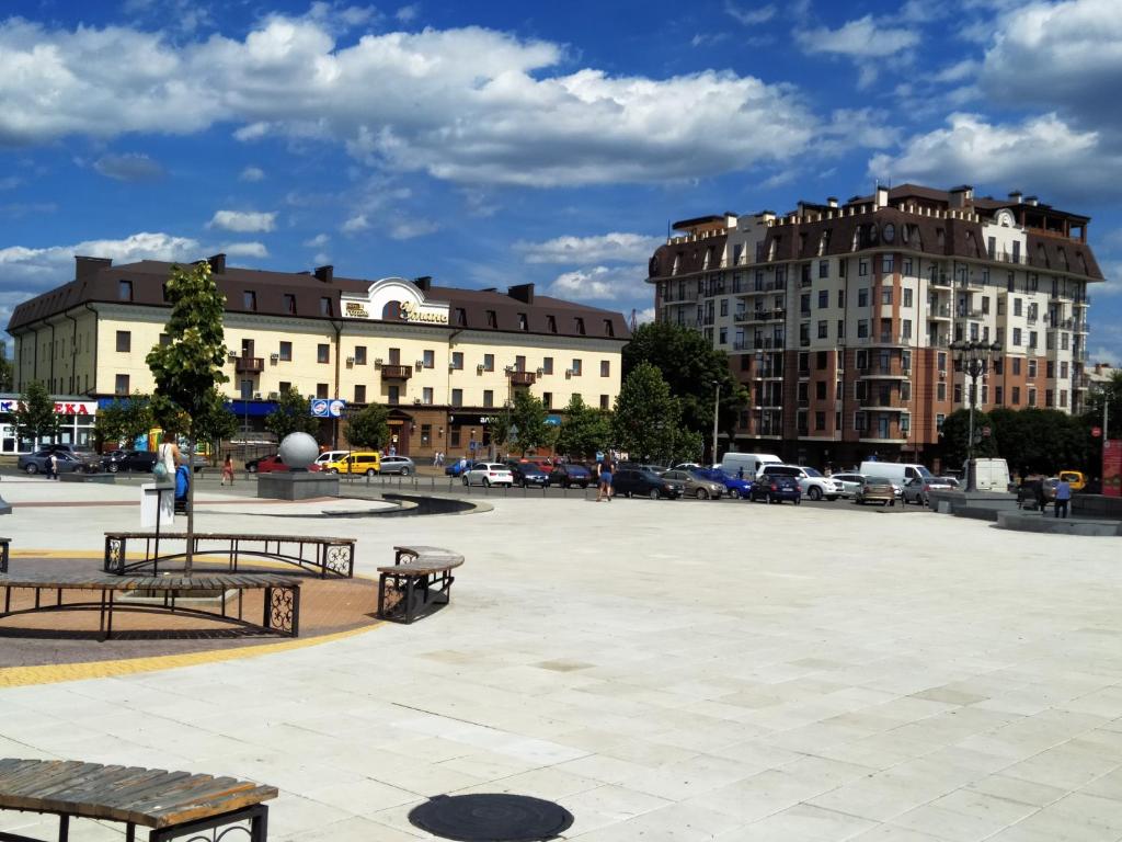 una plaza con bancos y edificios en una ciudad en Uman Hotel en Umanʼ