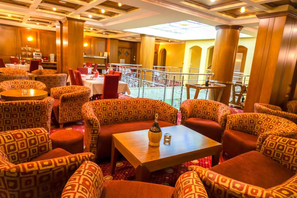 restauracja z krzesłami i stołem z butelką wina w obiekcie Hotel Ambasador Prishtina w Prisztinie