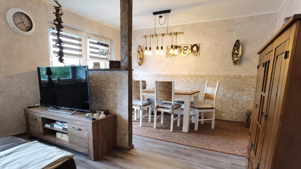 a living room with a television and a dining room at Feriensuite "Kappe Deluxe" in Winterberg