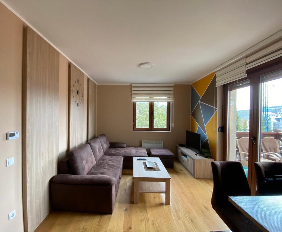 a living room with a couch and a table at Apartman Milenium & SPA in Zlatibor