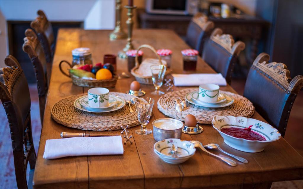 a wooden table with plates of food on it at Chambre Merlot, piscine et spa, proche St Emilion in Lugon et l’Ile du Carney