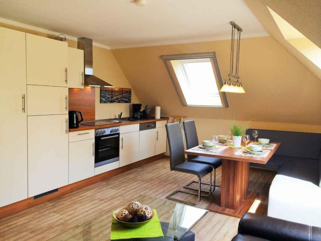 eine Küche und ein Esszimmer mit einem Tisch im Zimmer in der Unterkunft Haus der Seeadler - Appartementhaus Haus der Seeadler - Fewo 4 in Borchtitz