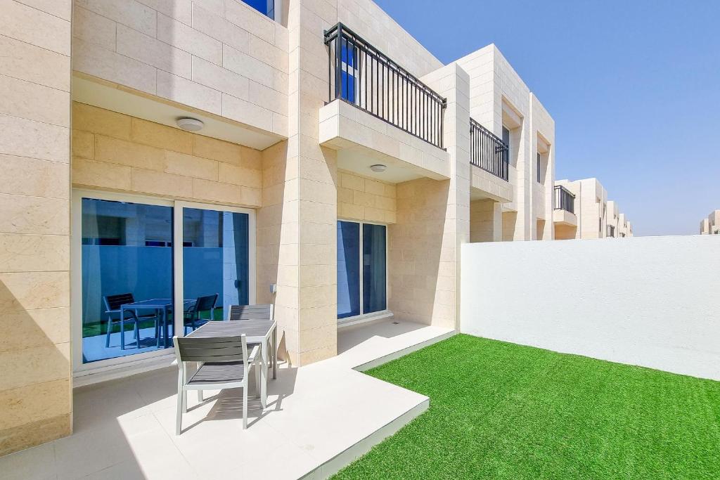 a house with a green lawn in front of it at ALH Vacay - DAMAC Hills 2 Victoria Villa in Dubai