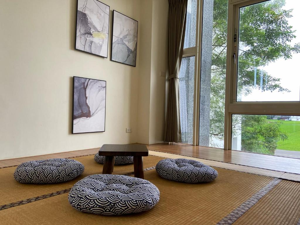 a room with three ottomans and a table and a window at I Leisure B&amp;B in Yuanshan