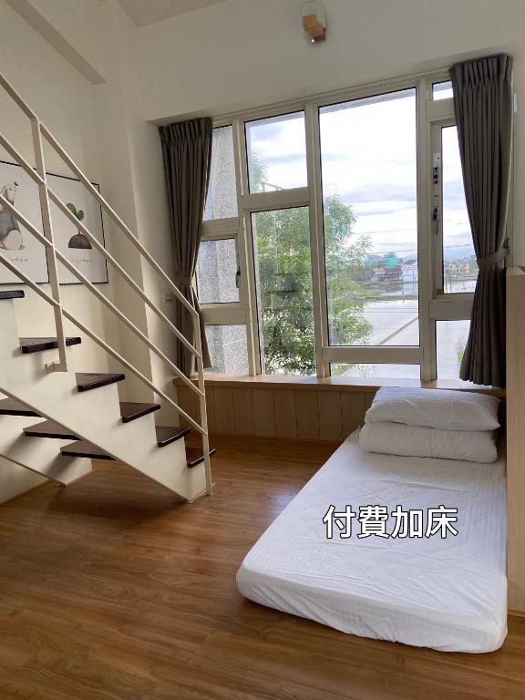 a room with a staircase and a bed and windows at I Leisure B&amp;B in Yuanshan