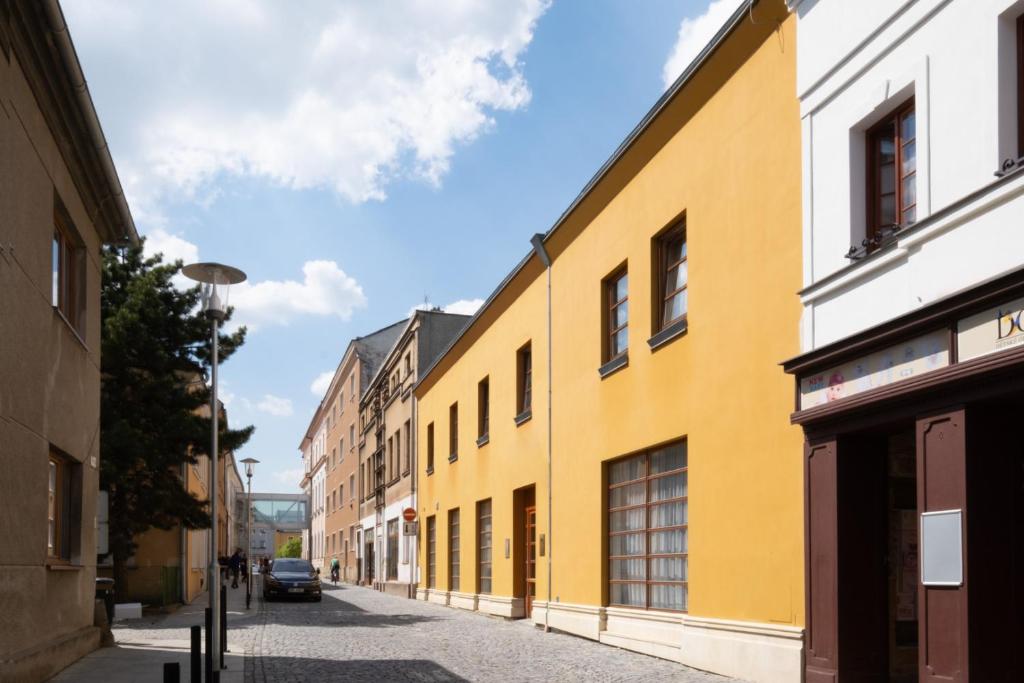 a yellow building on a street in a city at Hotel Mohelnice in Mohelnice