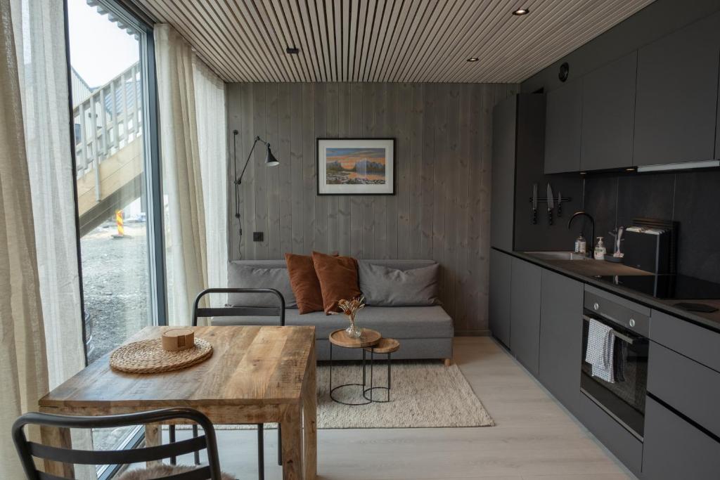 a kitchen and living room with a table and a couch at Modern apartment in Henningsvær in Lyngværet