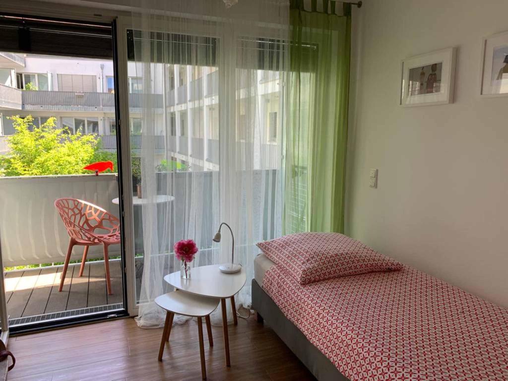Schlafzimmer mit einem Bett, einem Tisch und einem Fenster in der Unterkunft Ferienwohnungen Wolke in Regensburg